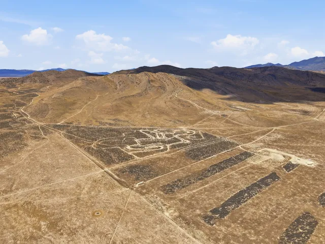 Expansive desert landscape featuring natural terrain and distant mountains