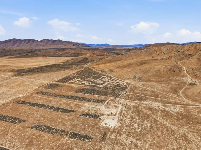 Expansive desert landscape featuring natural terrain and distant mountains
