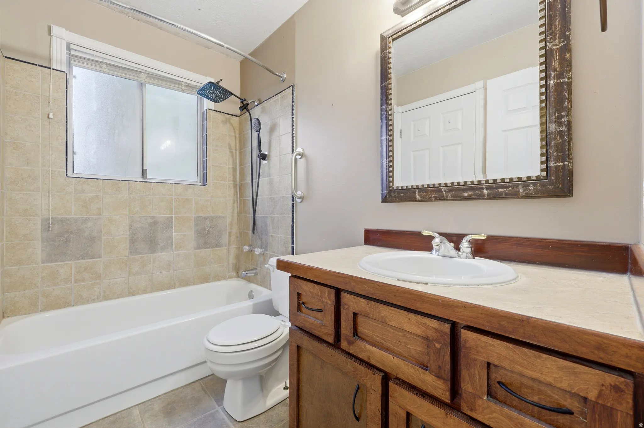 Master bathroom featuring a wood-finish vanity with dual sink configuration, white quartz countertop, and oil-rubbed bronze hardware