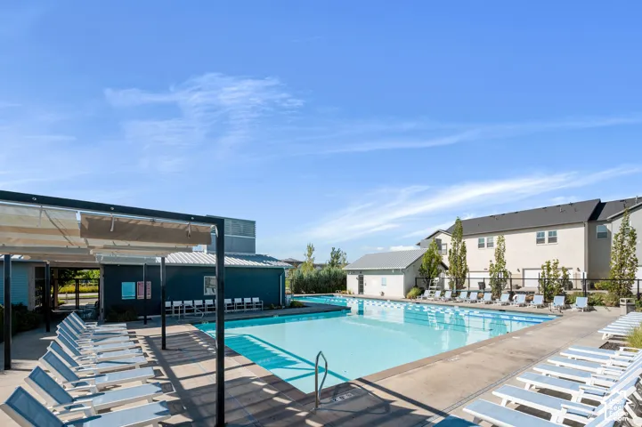 Expansive outdoor pool with integrated lap lanes, surrounded by concrete decking and multiple lounge chairs