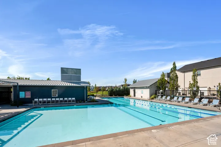 Community swimming pool featuring a lap lane, surrounding concrete decking, and adjacent cabana structure