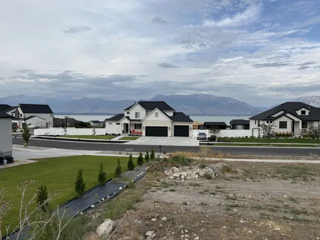 Stunning new construction estate featuring modern architectural design with clean lines, multiple gabled rooflines, and expansive dark-trimmed garage doors