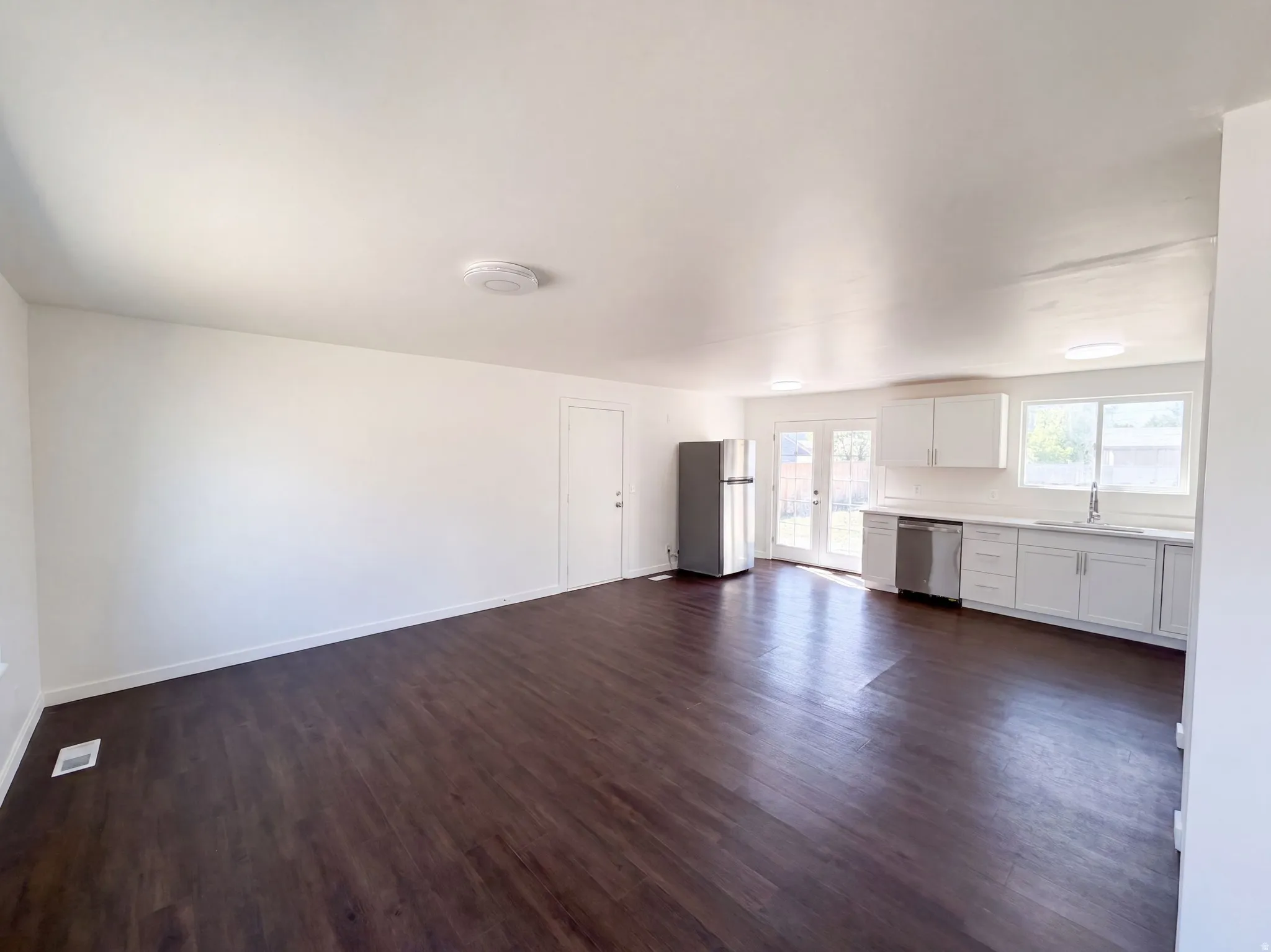 Wood-finish flooring throughout, white walls, and recessed lighting