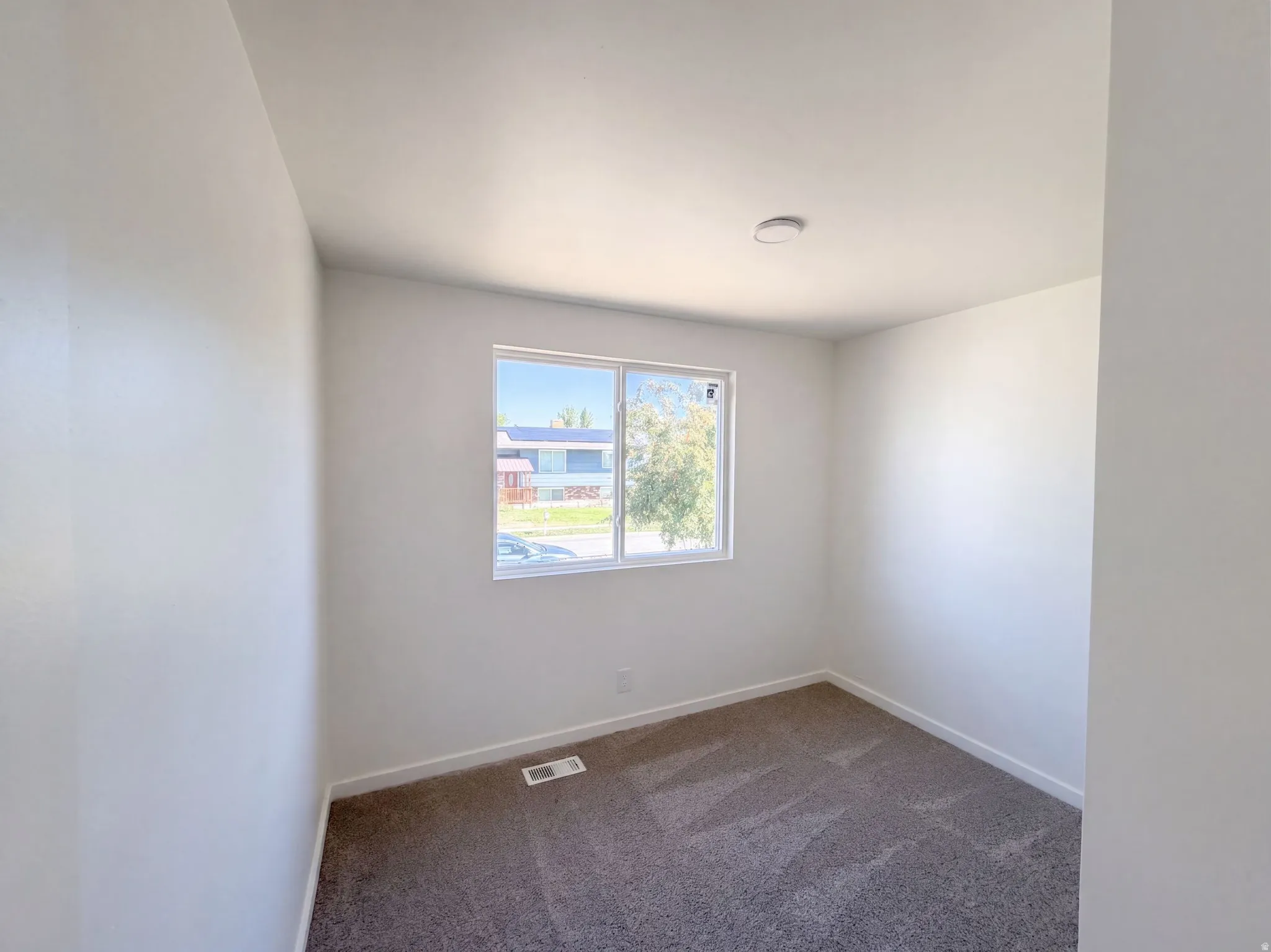 Neutral wall paint, window with exterior exposure, recessed ceiling light, and carpet flooring