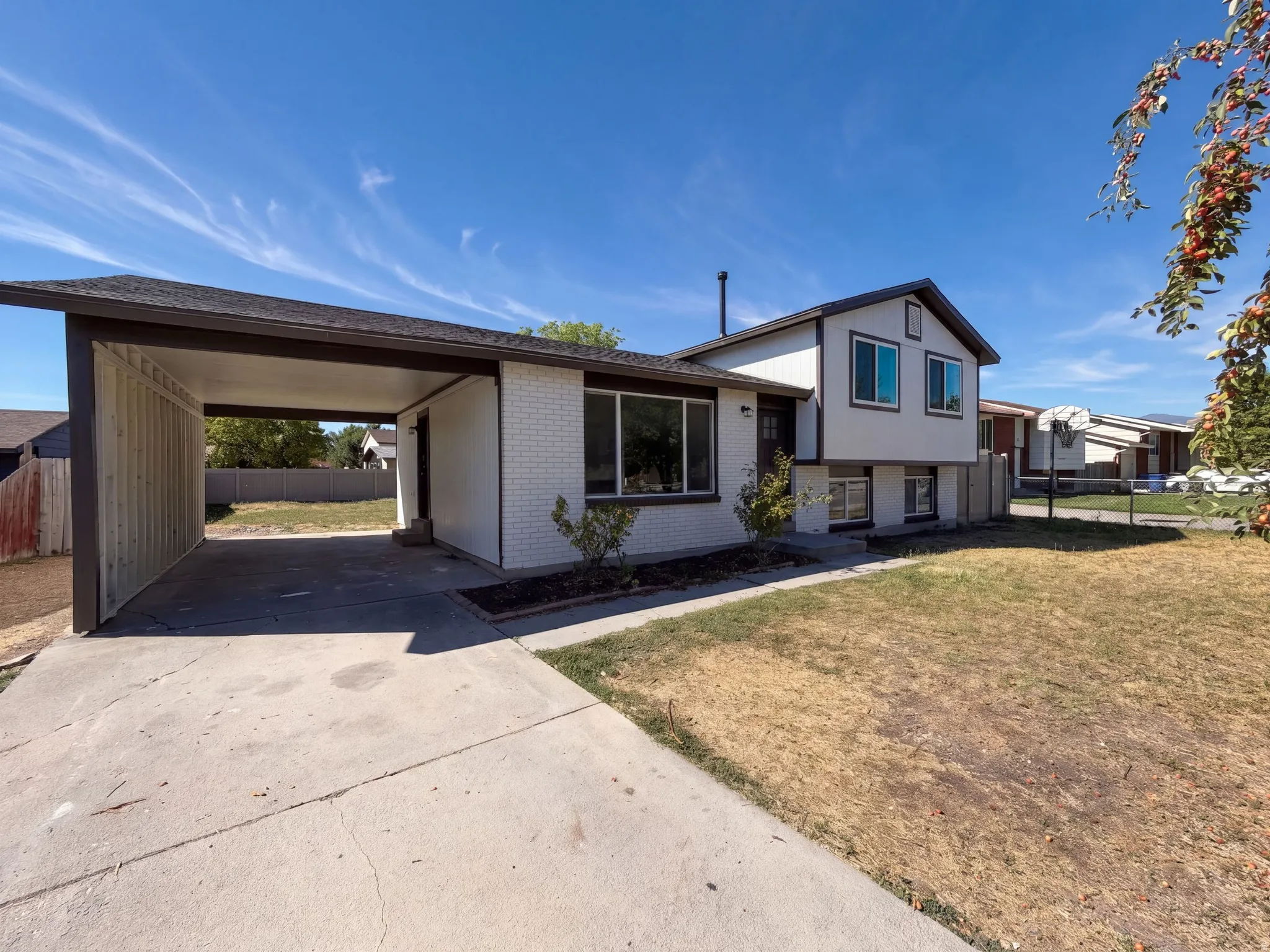 Two-story exterior with a carport, front entry, and a concrete driveway