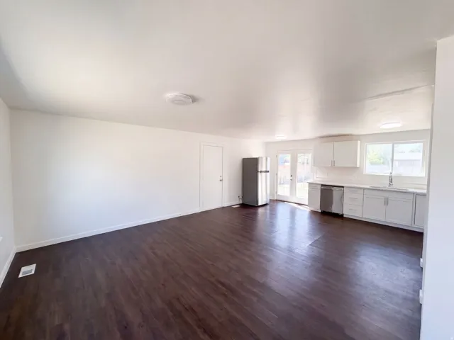 Wood-finish flooring throughout, white walls, and recessed lighting