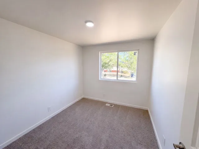 Neutral tone walls with recessed lighting and a window