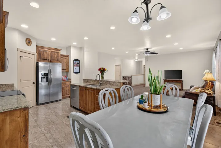 Kitchen and dining area featuring wood cabinetry, stainless steel appliances, and recessed lighting