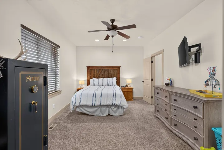 Recessed lighting, ceiling fan, textured carpet flooring, wood-finish door, and wood-finish window blinds