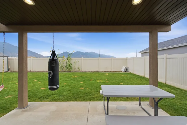 Covered patio with recessed lighting, concrete flooring, and a expansive grassy yard