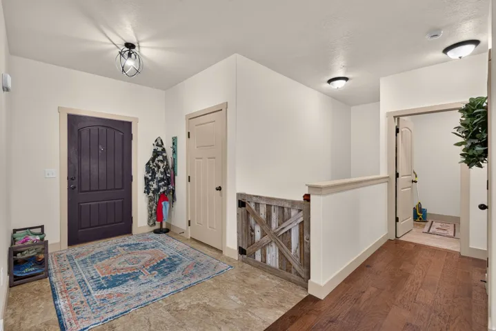 Entryway featuring a dark wood arched panel door, tile flooring, and a half wall with a decorative wood gate