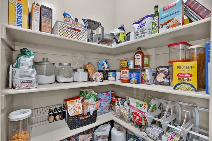 Built-in pantry shelving with multiple levels, featuring a corner configuration and neutral-toned finishes
