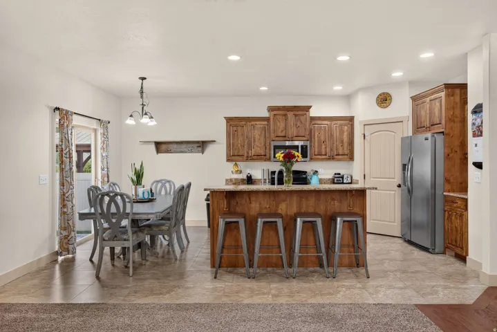 Kitchen featuring wood cabinetry, stainless steel appliances, and a central island with bar seating