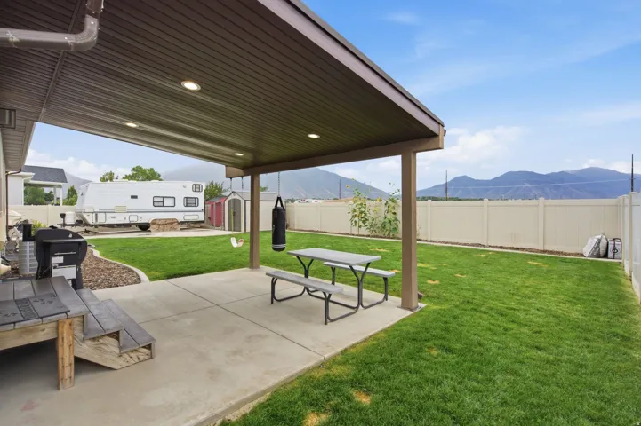 Covered patio with recessed lighting, concrete surface, and a manicured lawn
