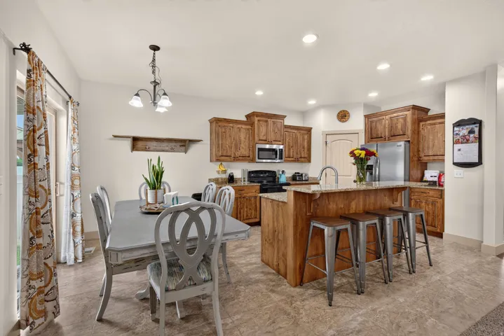 Kitchen featuring wood cabinetry, an island with countertop seating, and recessed lighting