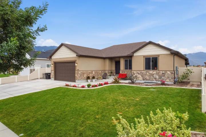 Single-story exterior with a two-tone facade, stone veneer detailing, and an attached garage