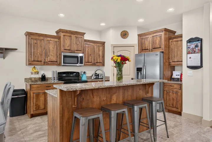 Kitchen featuring wood cabinetry, granite countertops, and stainless steel appliances