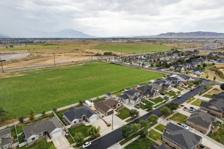 Expansive green space bordering a residential community with distant mountain scenery