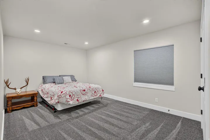Recessed lighting, light-toned walls, and grey patterned carpeting