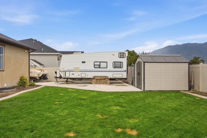 Expansive concrete pad, lawn area, and a utility shed with a gable roof