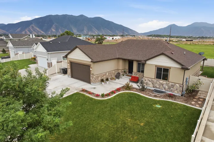Single-story residence featuring a brown asphalt shingle roof, stone and stucco exterior, and an attached two-car garage