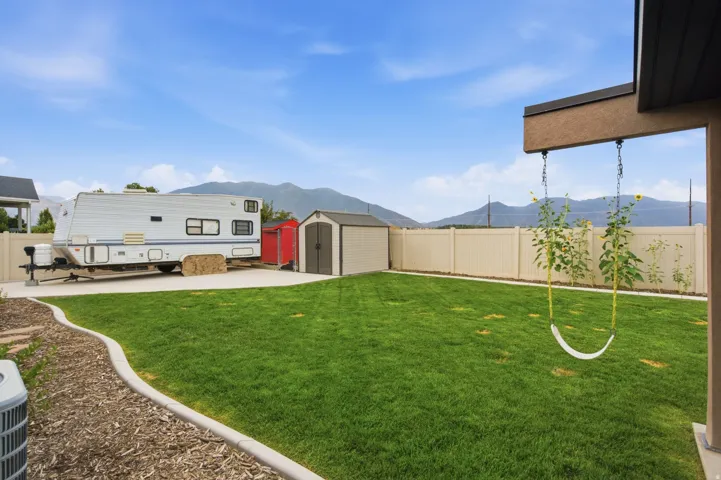 Spacious backyard featuring a manicured lawn, concrete patio, and privacy fencing