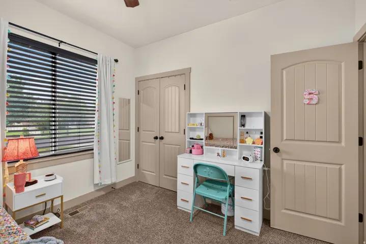 Carpeted flooring, recessed window, paneled interior doors, and a ceiling fan