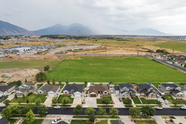 Residential neighborhood with established trees and manicured lawns, set against a backdrop of distant mountains