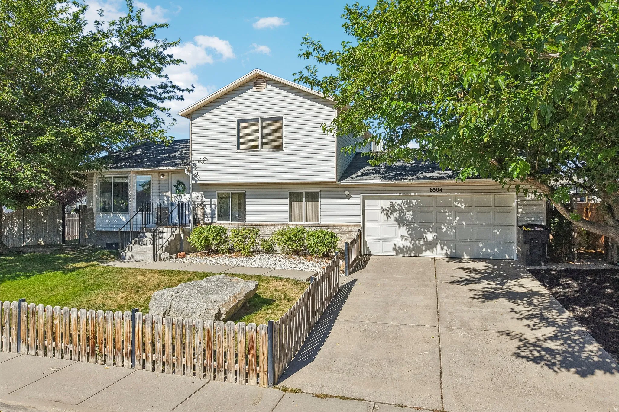 Siding exterior with a covered entry, concrete driveway, and an attached two-car garage