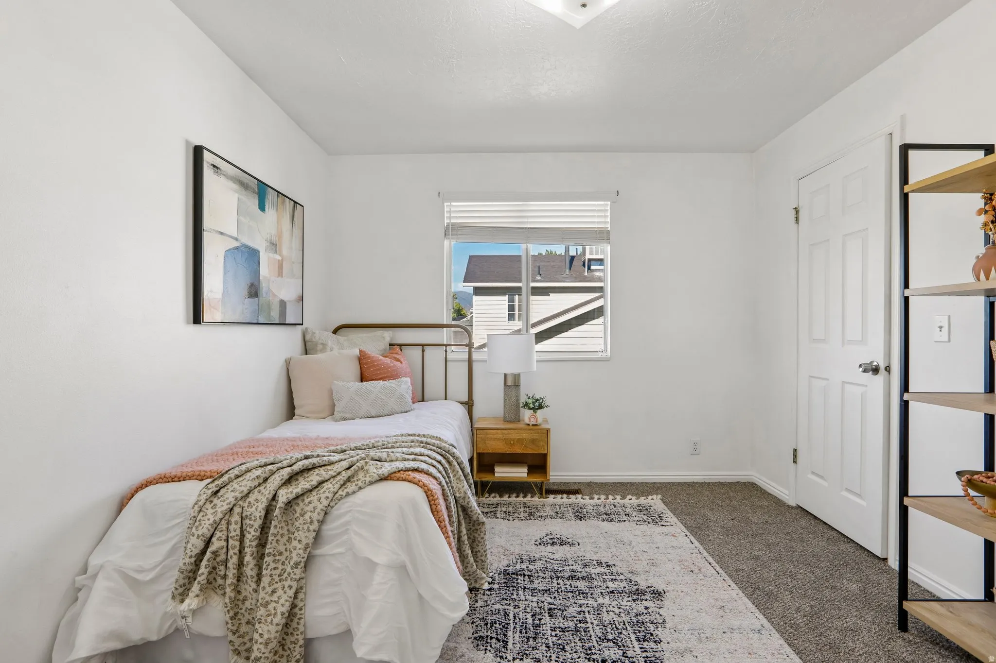 Carpeted flooring, white walls, and a multi-pane window with horizontal blinds