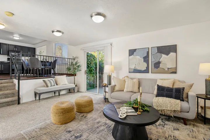 Sunken living area with sliding glass door access to the exterior, carpeted flooring, and recessed lighting