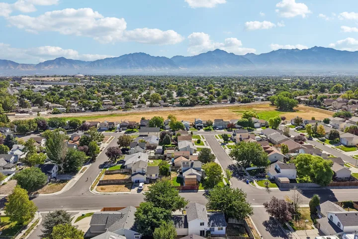 Residential neighborhood with established streets and mature trees, set against a backdrop of distant mountains