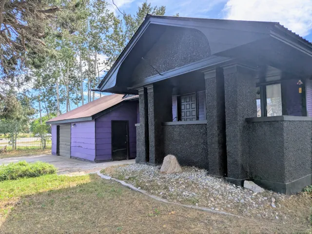Stucco exterior with a covered porch and decorative columns