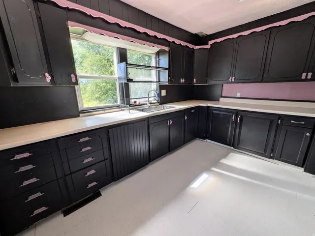 Expansive cabinetry with varied drawer and cabinet configurations, light-toned countertops, and a double-basin sink