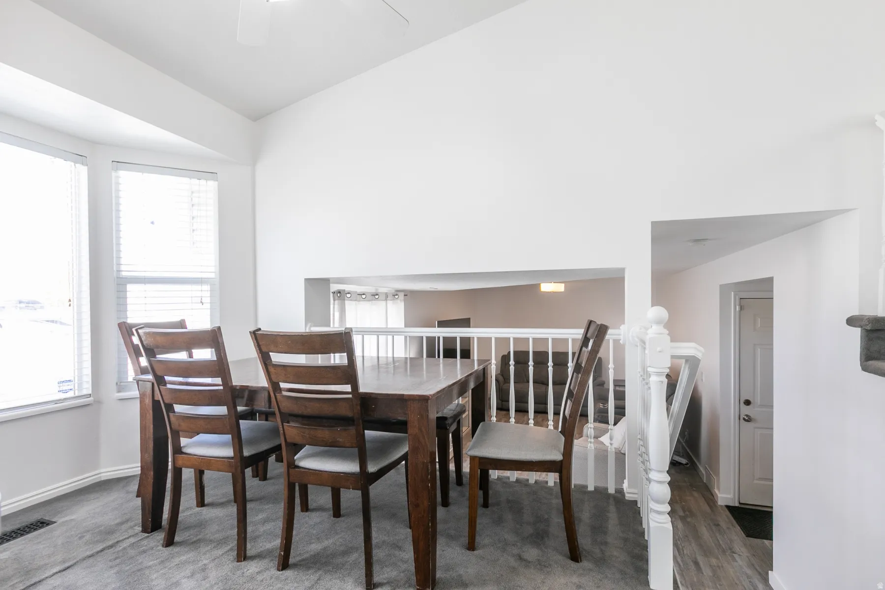 Dining area featuring a vaulted ceiling and an open architectural cut-out