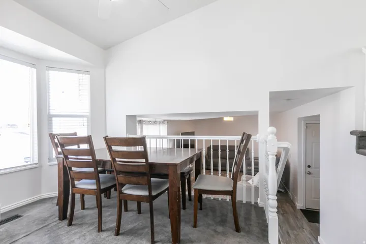 Dining area featuring a vaulted ceiling and an open architectural cut-out