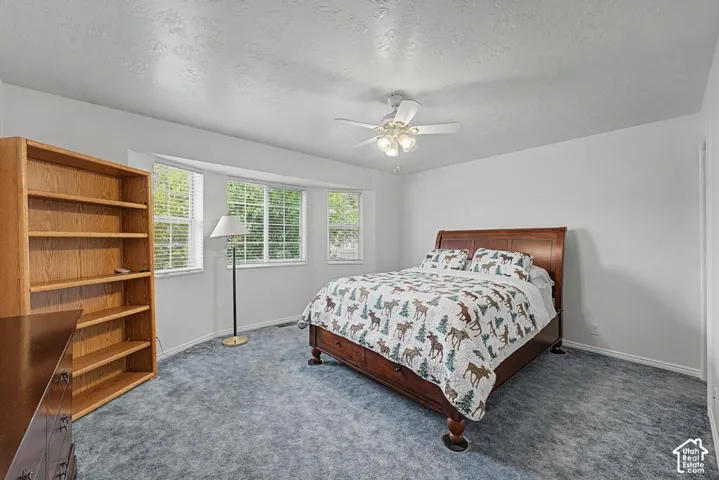 Recessed bay windows with blinds, ceiling fan with light fixture, and light-toned wall paint.