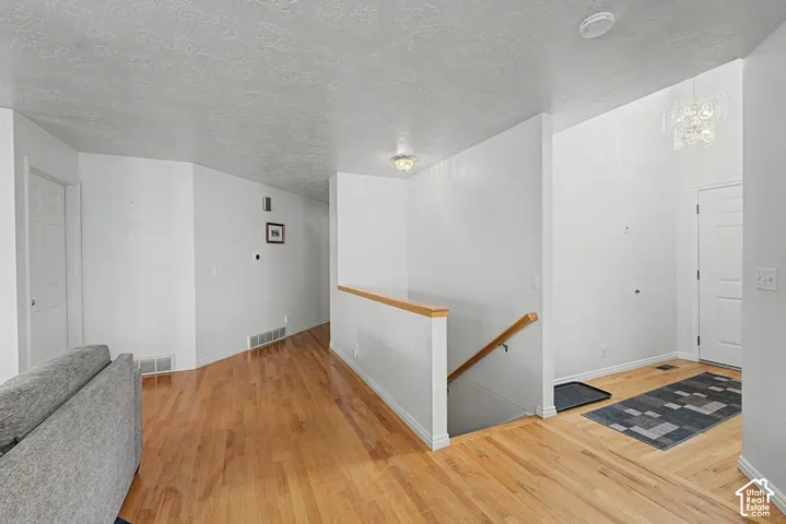 Hardwood flooring throughout, white painted walls.