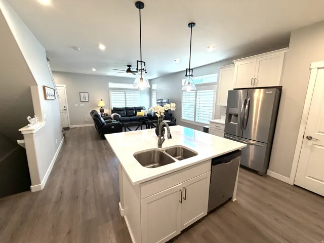 Open-concept living space featuring wood-finish flooring, recessed lighting, and white plantation shutters