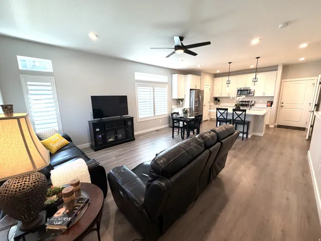 Open-concept living space featuring wood-finish flooring, recessed lighting, and a ceiling fan