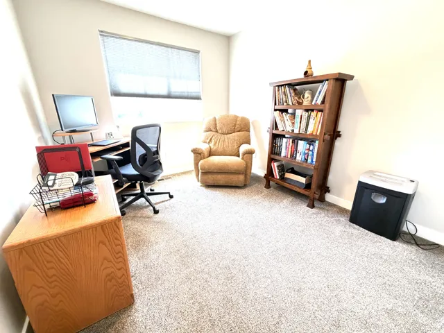 Neutral wall color, light-toned carpet, and a window with blinds