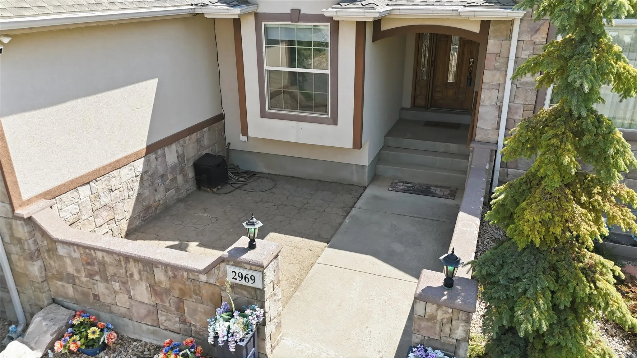 Stone veneer facade with stucco accents and a multi-pane front window