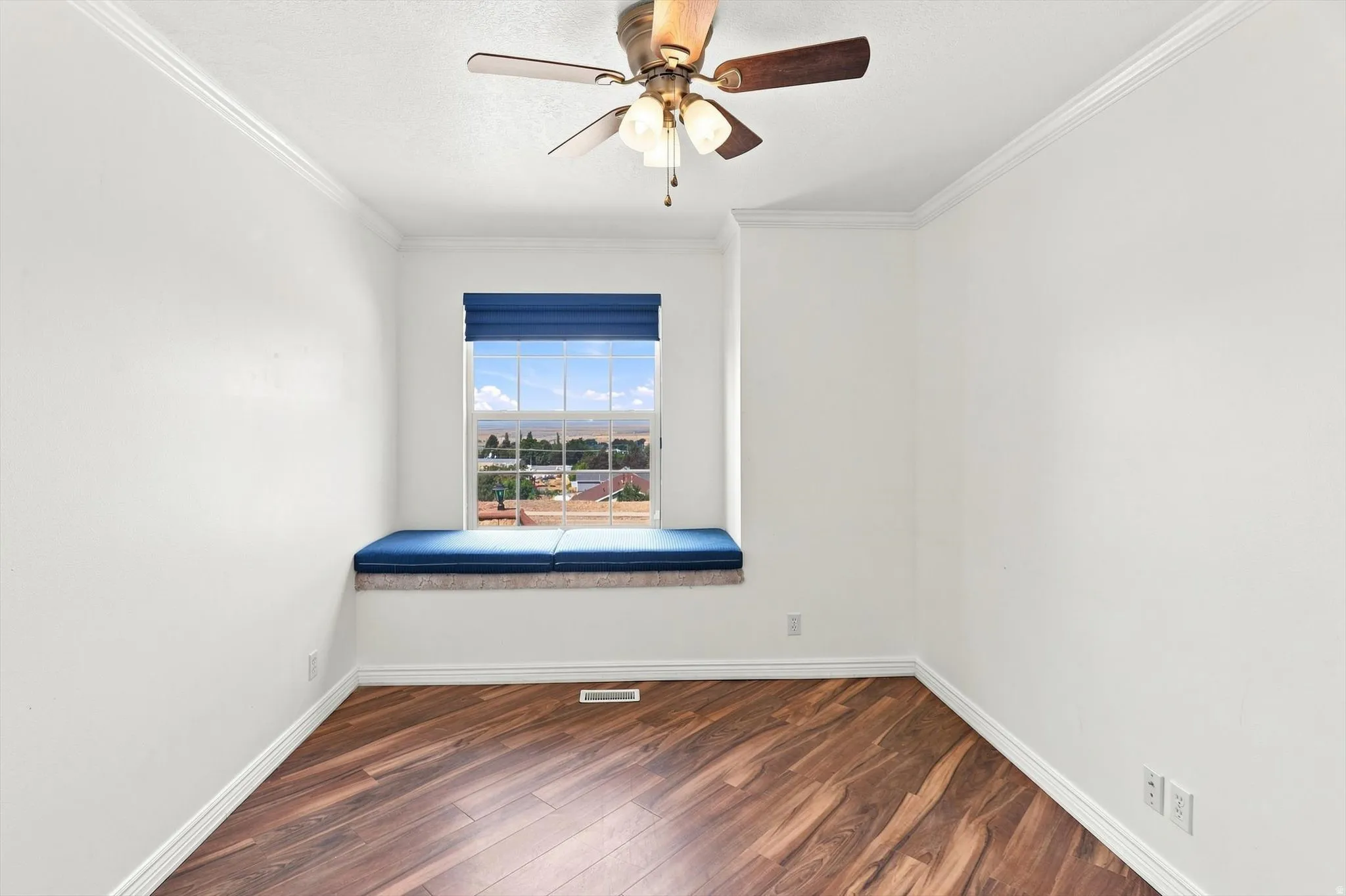 Wood-finish flooring, built-in window seating, recessed window, and a ceiling fan with integrated lighting