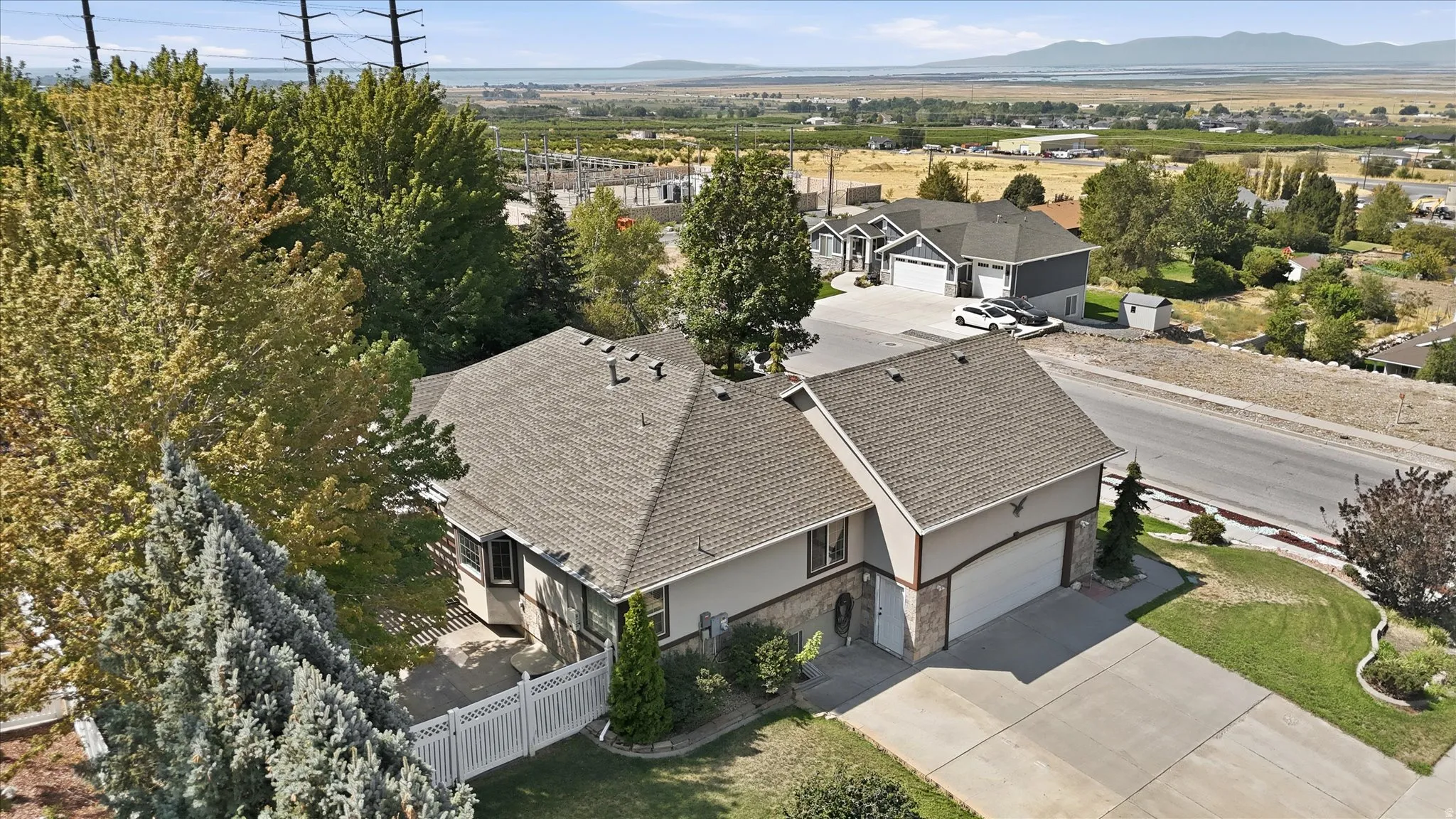 Two-story residence with an attached two-car garage, featuring a shingled roof and a paved driveway