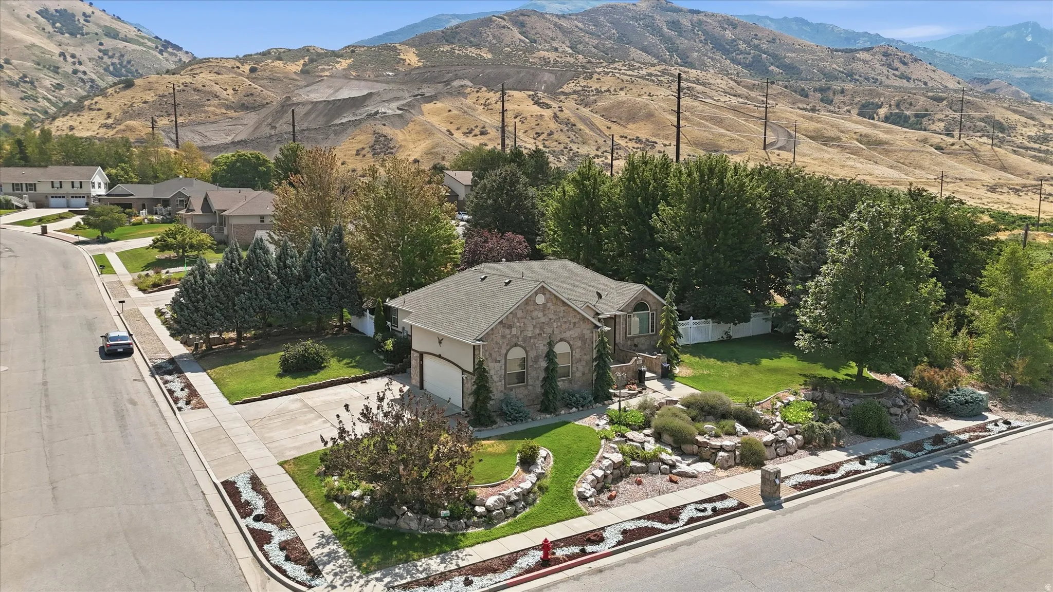 Stone exterior residence featuring an attached garage and a concrete driveway