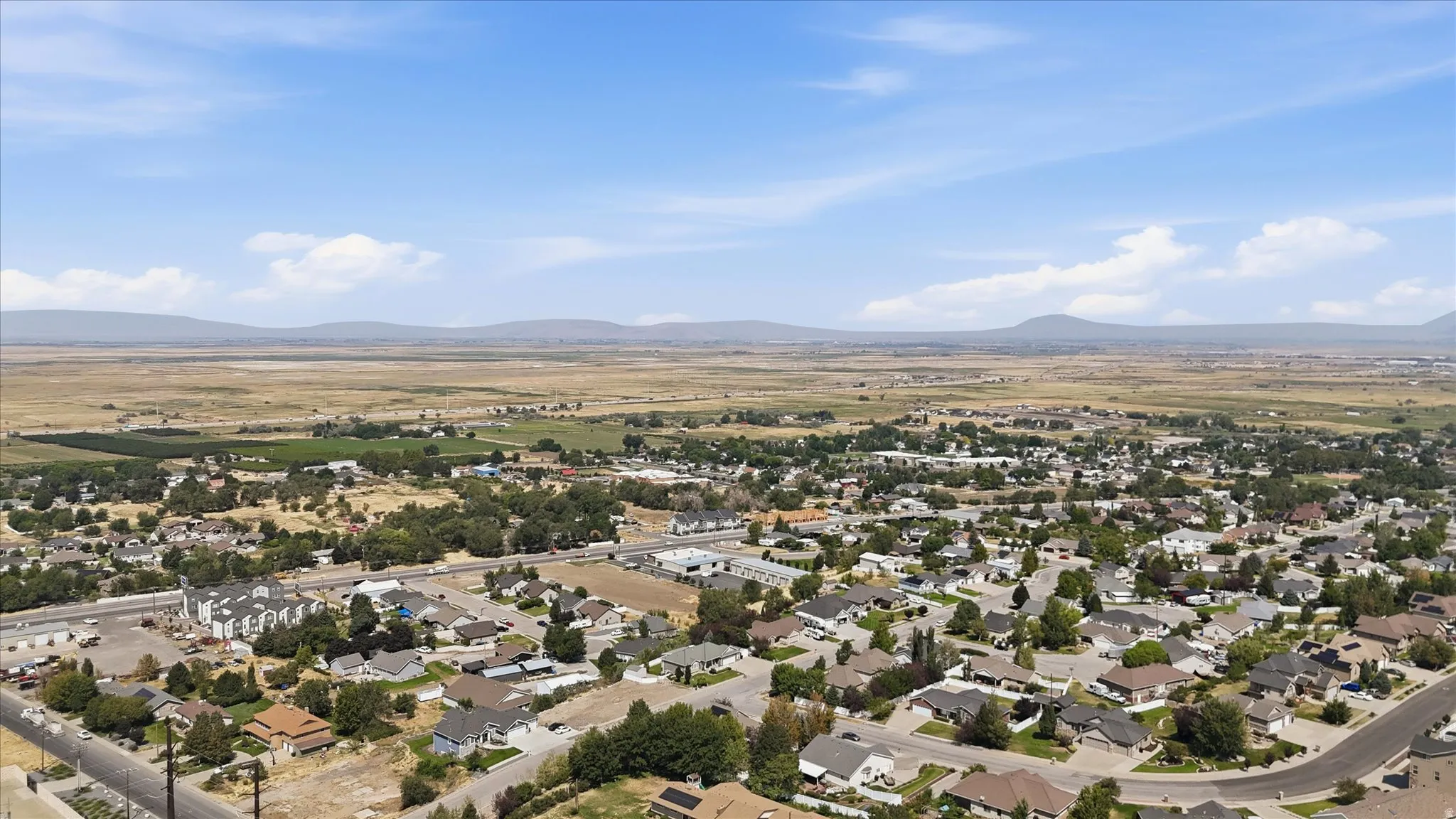 Aerial perspective of a developed residential area with numerous single-story homes and mature trees