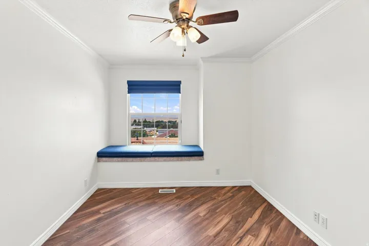 Wood-finish flooring, built-in window seating, recessed window, and a ceiling fan with integrated lighting