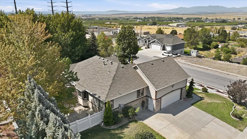Two-story residence with an attached two-car garage, featuring a shingled roof and a paved driveway