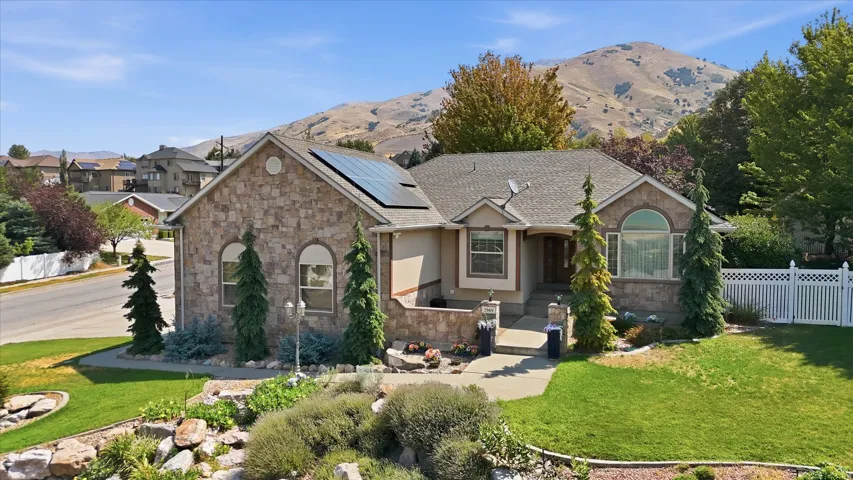 Stone veneer exterior with a gabled roof and solar panels
