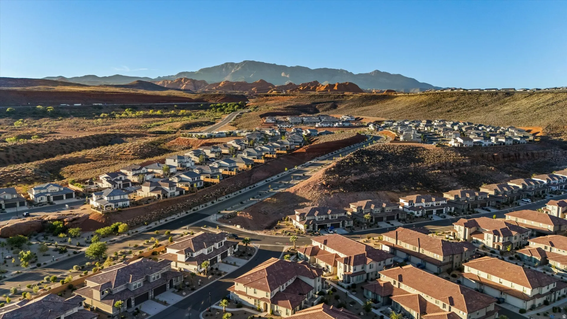 Residential development with varying rooflines and building materials, featuring mountain and desert terrain
